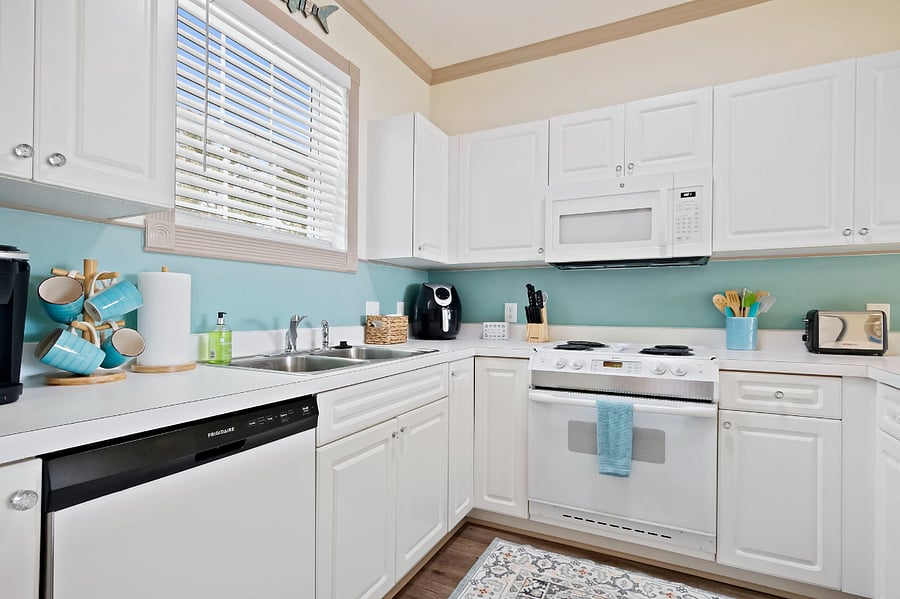 The kitchen is well-stocked with ample dishes and cookware.