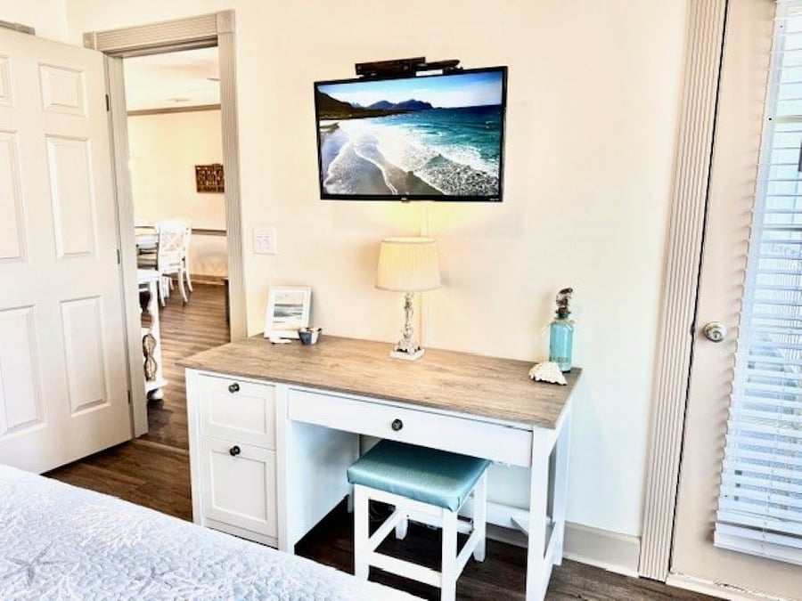 The main bedroom features a desk, with a Smart TV and cable.