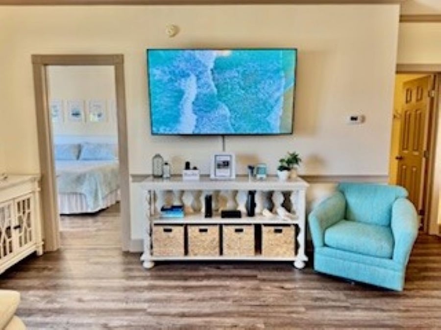 The living room has a 65" TV with cable and leather sofas.