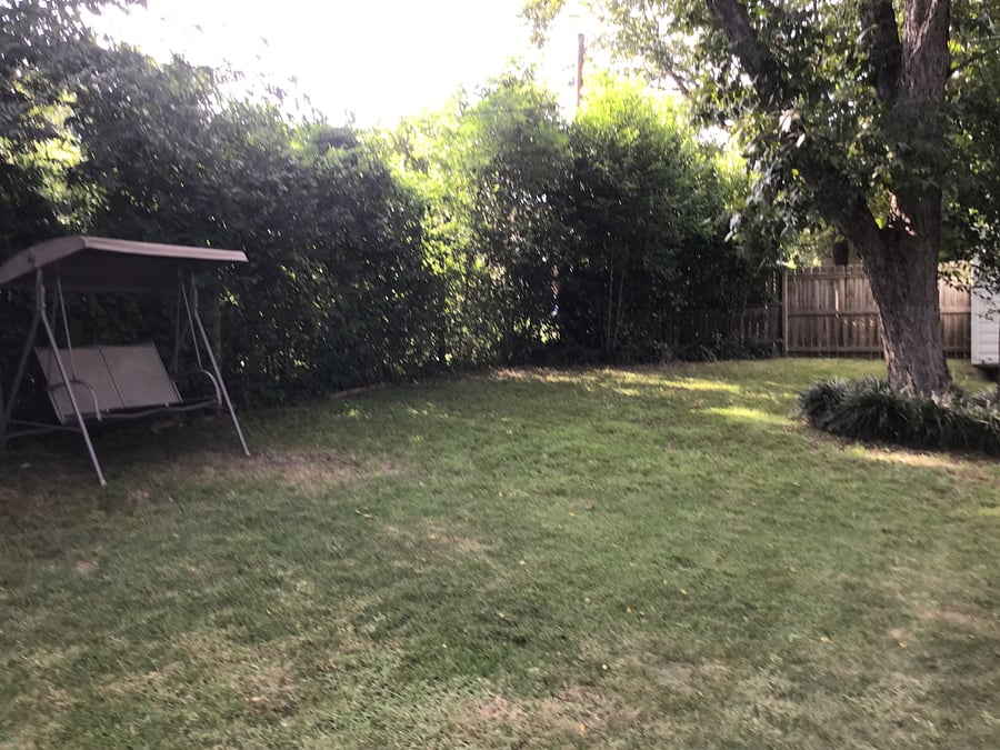 Backyard includes a swing and table with 6 chairs plus large umbrella.