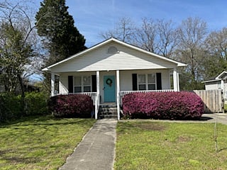 Front of house with a welcoming front porch. There are 3 steps to enter house.  Parking is to the right.