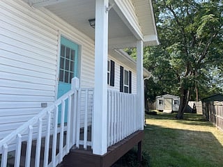 back door/ small, covered porch leading to fenced in back yard