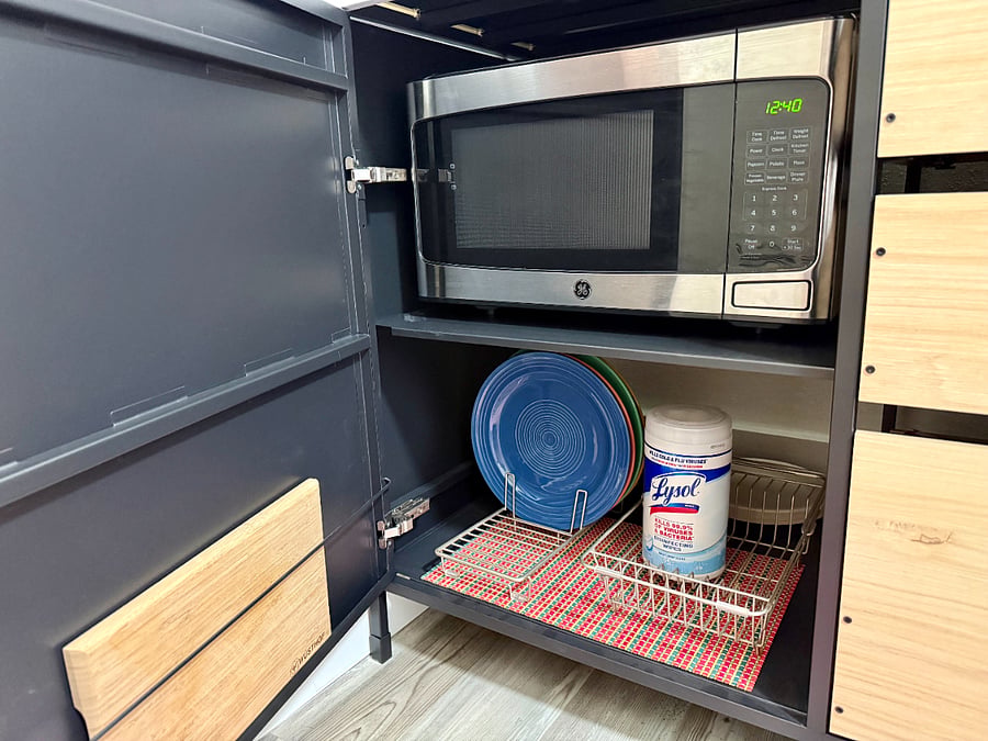 Microwave, dinner plates, and cutting board are under the counter.