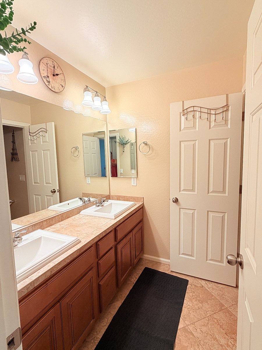 Shared bathroom with tub/shower and plenty of bright lighting.