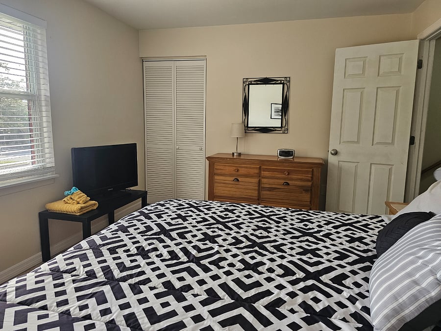 Master bedroom with California king sized bed, and TV