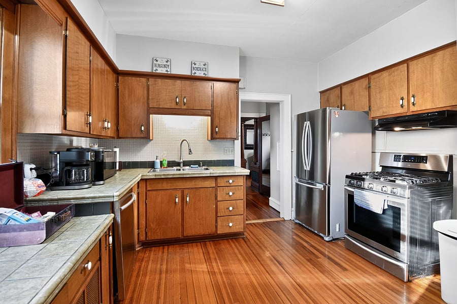Fully equipped Omaha kitchen with vintage wood cabinetry. Cook your meals with ease.