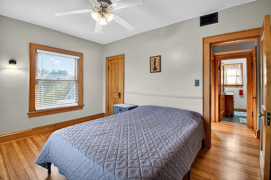 Peaceful bedroom with cozy wooden ambiance and plenty of natural light.