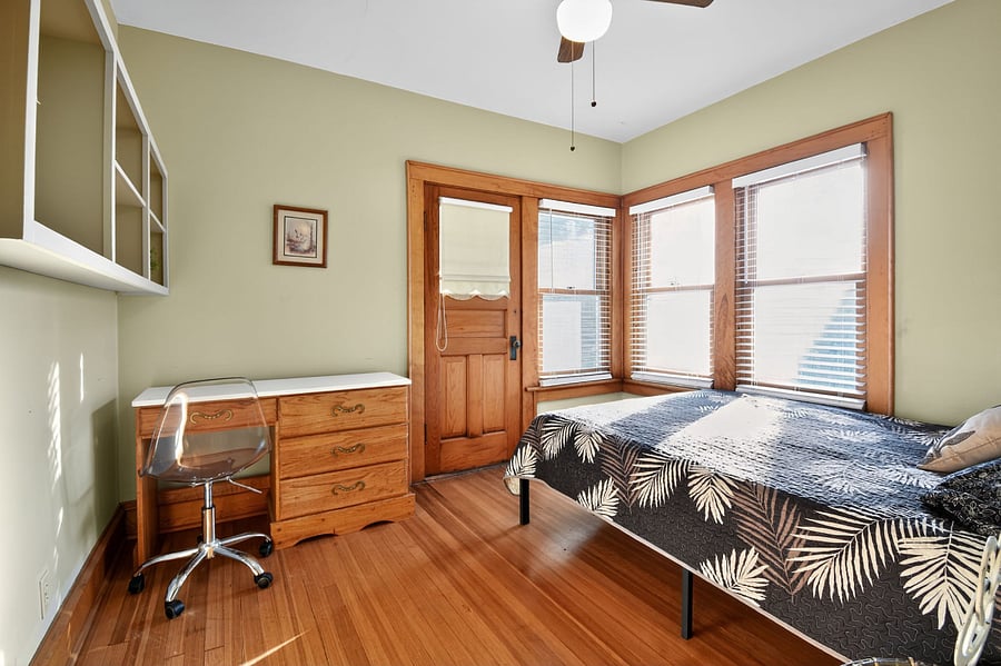 Relax in this warm Omaha bedroom featuring timeless wooden dcor and plush bedding with a desk and a chair