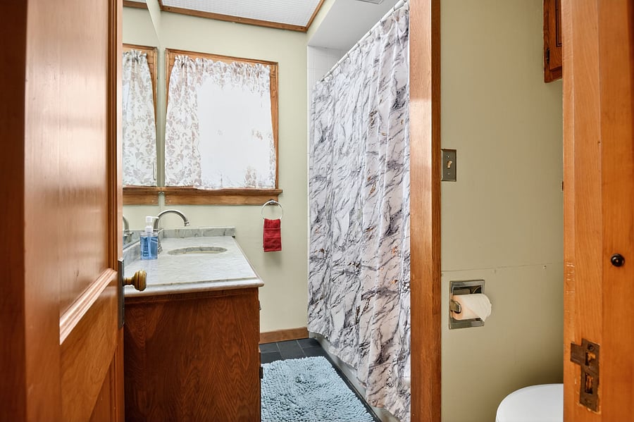 Full bath with classic fixtures and cozy, old-home character.