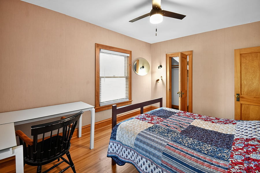 Relax in this warm Omaha bedroom featuring timeless wooden dcor and plush bedding.