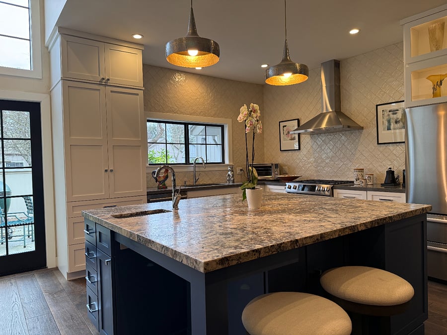 an oversized granite island with prep sink perfect for 2 cooks