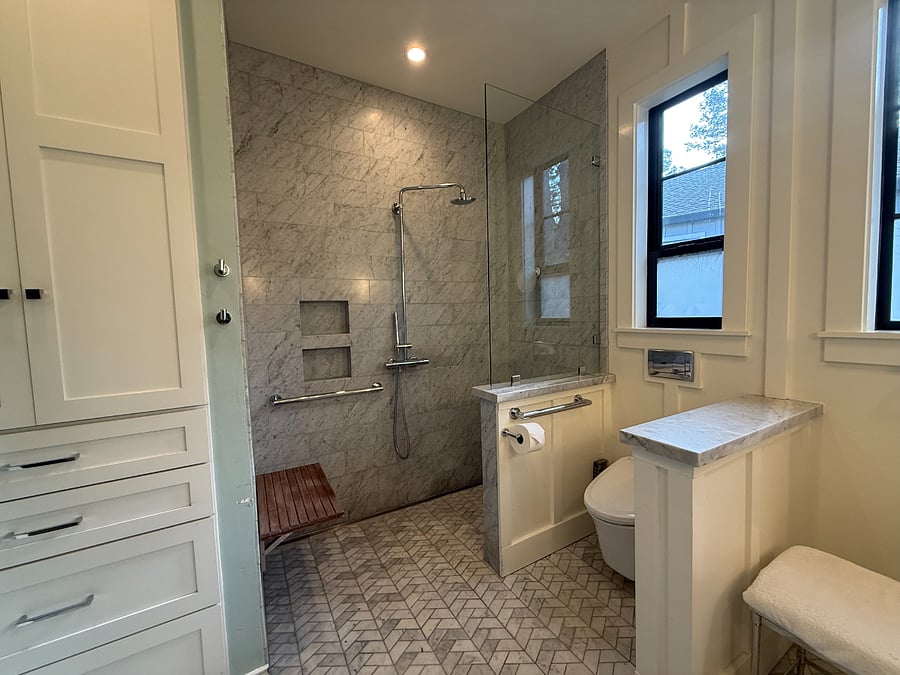 the primary bathroom has an attached shower bench and grab bars for safety