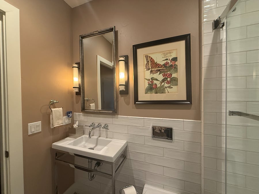 wall sconces adorn the 2nd bathroom, with overhead lighting for a bright area