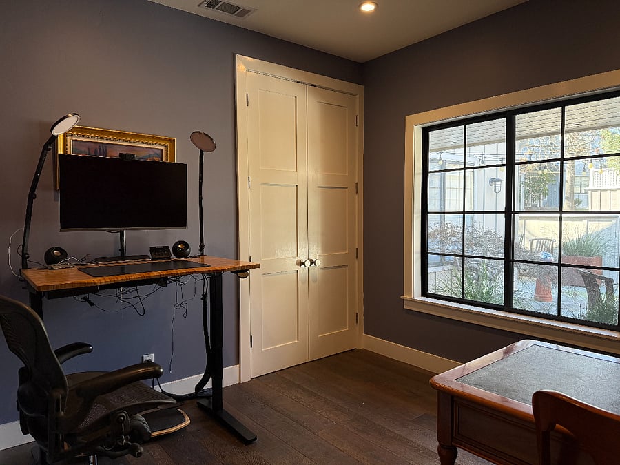 An office with 2 desks- 1 traditional and 1standing/sitting; plenty of storage