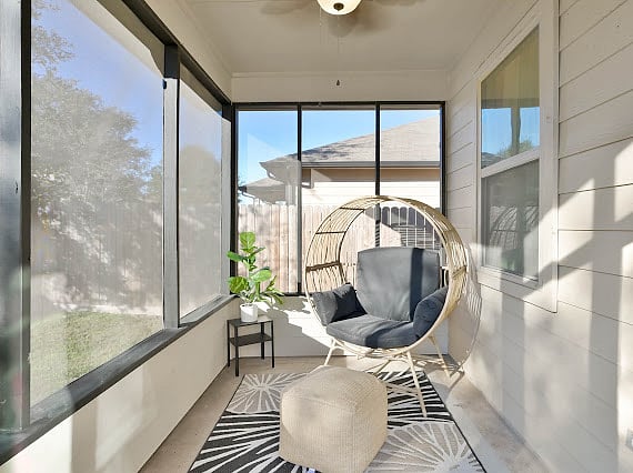 Screened in back patio with lounge chair and propane grill