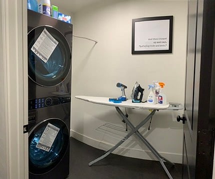 Laundry room includes ironing board, iron and initial supplies. 