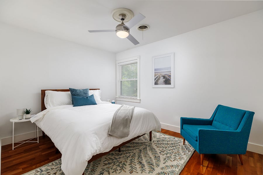 Relax and recharge in this tranquil guest room featuring crisp white linens, rich blue accents, and peaceful natural light.