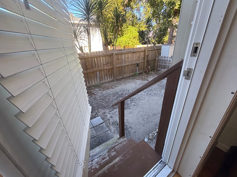 Doorway from office or 2nd bedroom leading to a private outdoor yard area that is fenced off separately from any other space in the yard of the property