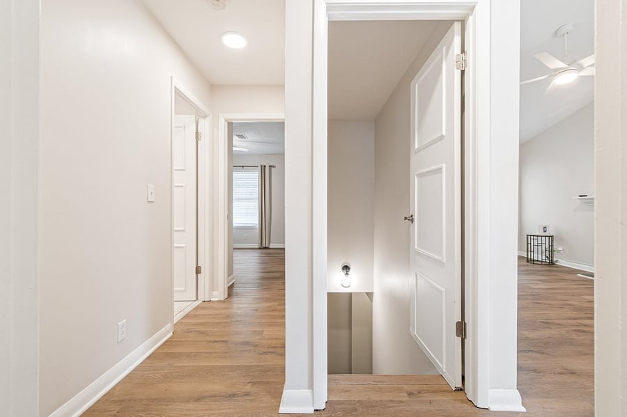 hallway to 2nd bedroom, (left) stairs down to laundry room (center), Living room (right)