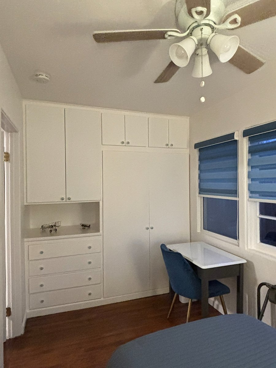 Smaller bedroom / office located off the living room, with single bed, cabinets and dedicated desk space. 