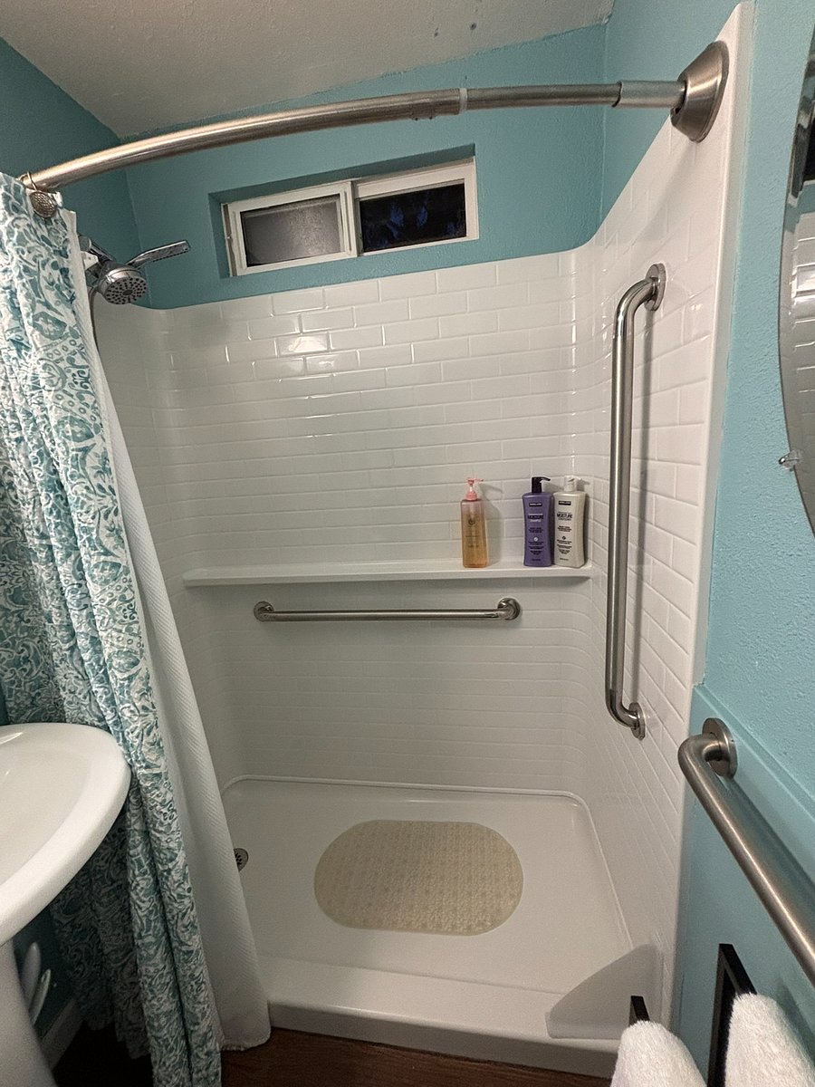 Grab bars installed in shower and in front of toilet.