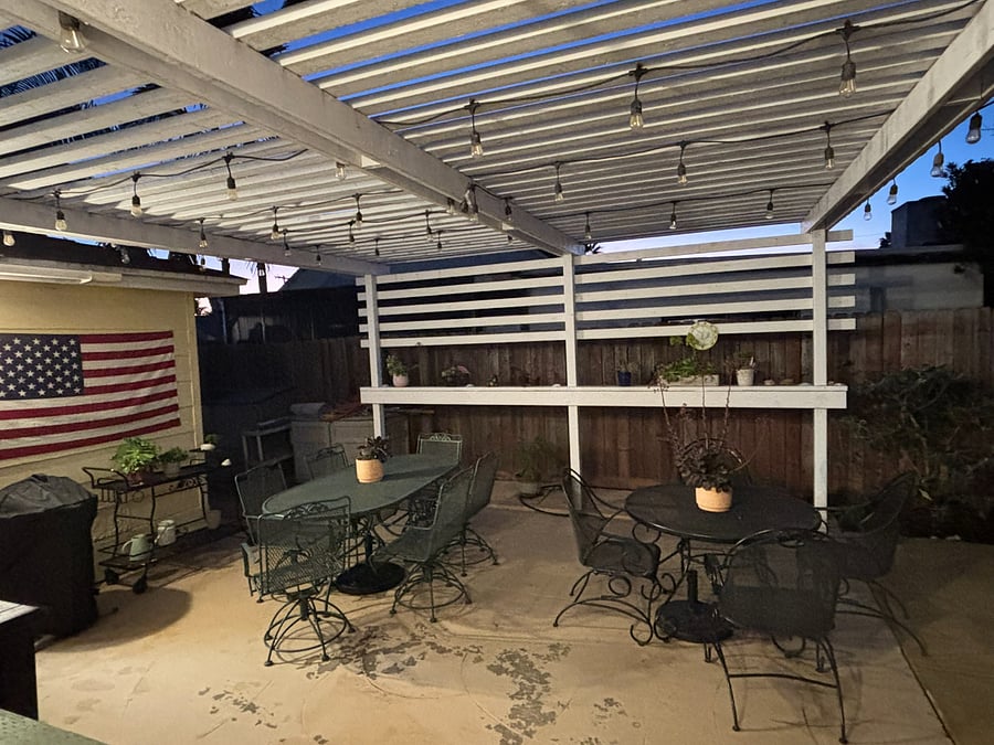 Semi-covered outdoor patio with seating for over 10 people. 