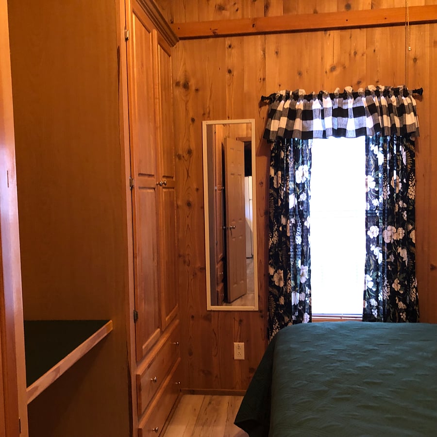 Primary bedroom with closet, queen bed, and dressing table