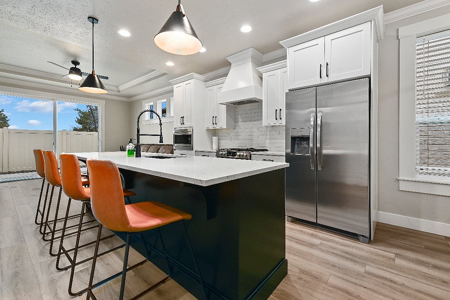 Kitchen featuring a large island with four modern barstools and all appliances in excellent working condition.