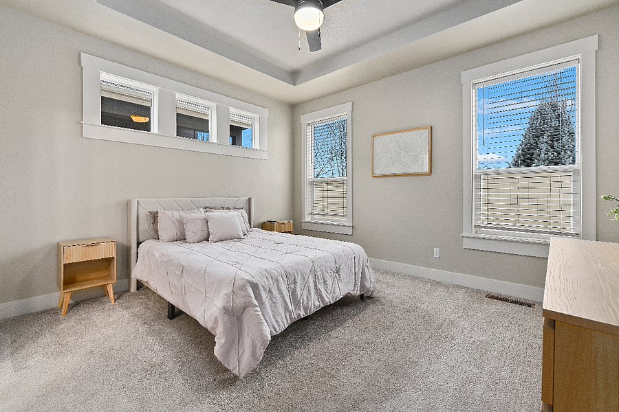 Comfortable downstairs primary bedroom featuring a queen-size bed, matching nightstands, six-drawer dresser, and Smart TV.