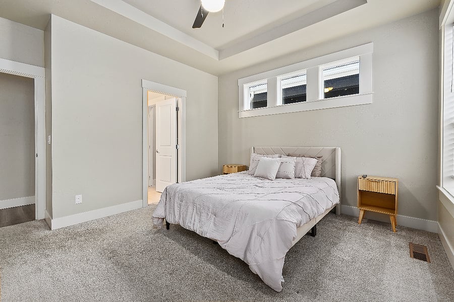 Comfortable downstairs primary bedroom featuring a queen-size bed, matching nightstands, six-drawer dresser, and Smart TV.
