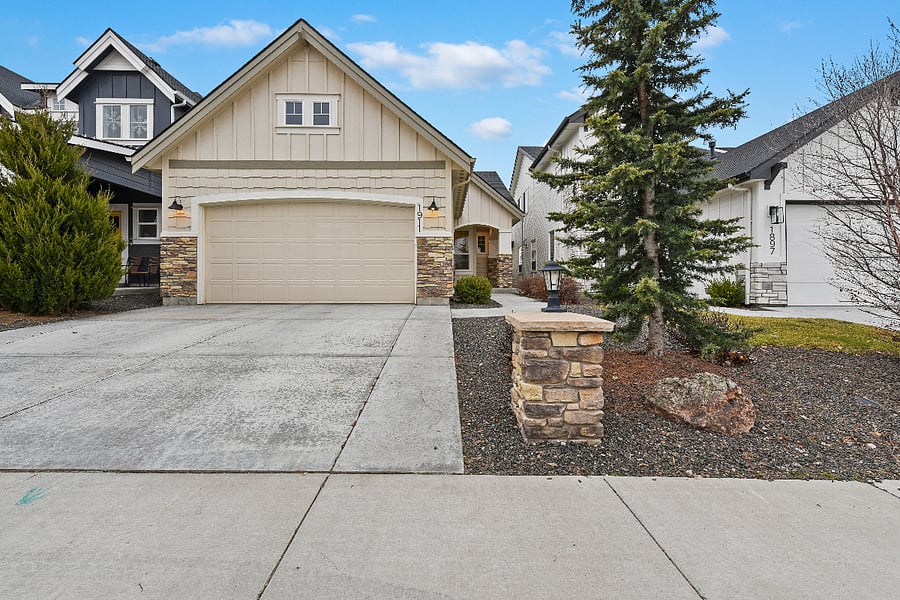 Home exterior with two-car garage, additional driveway parking for two vehicles, and low-maintenance front yard.