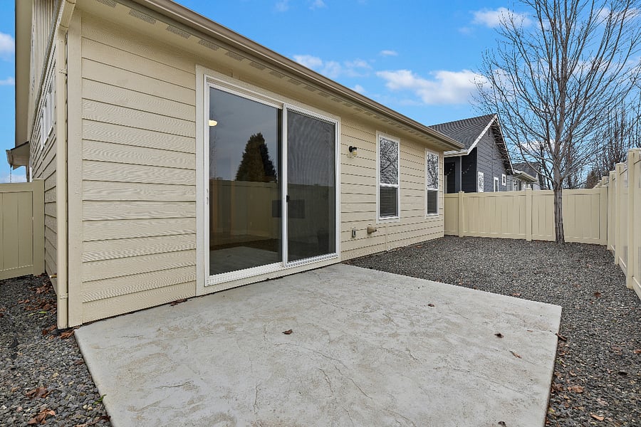 Low-maintenance backyard with vinyl fencing and river rock landscaping.