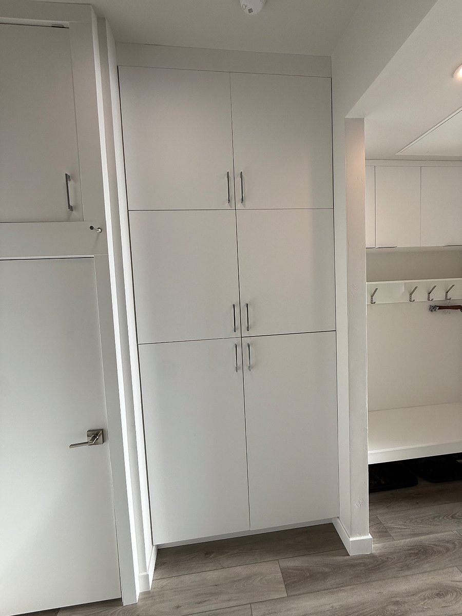 Spacious closet with built-in storage and wall-mounted hooks for coats and gear.