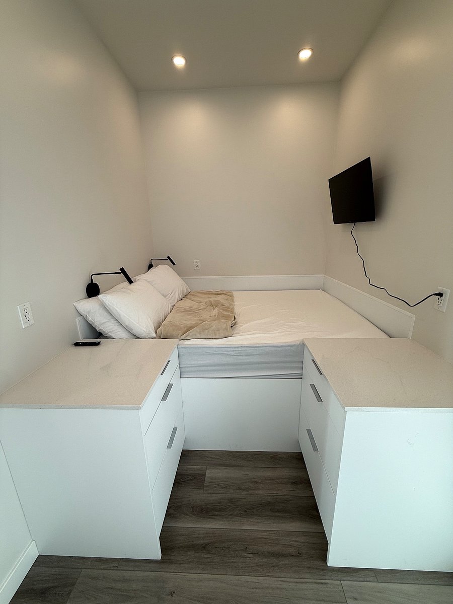 Queen-size bed with clean linens and built-in storage.
