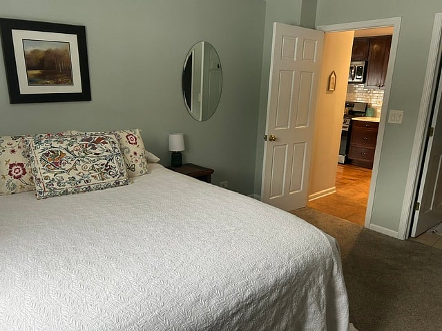 Primary bedroom with queen bed and attached half bath