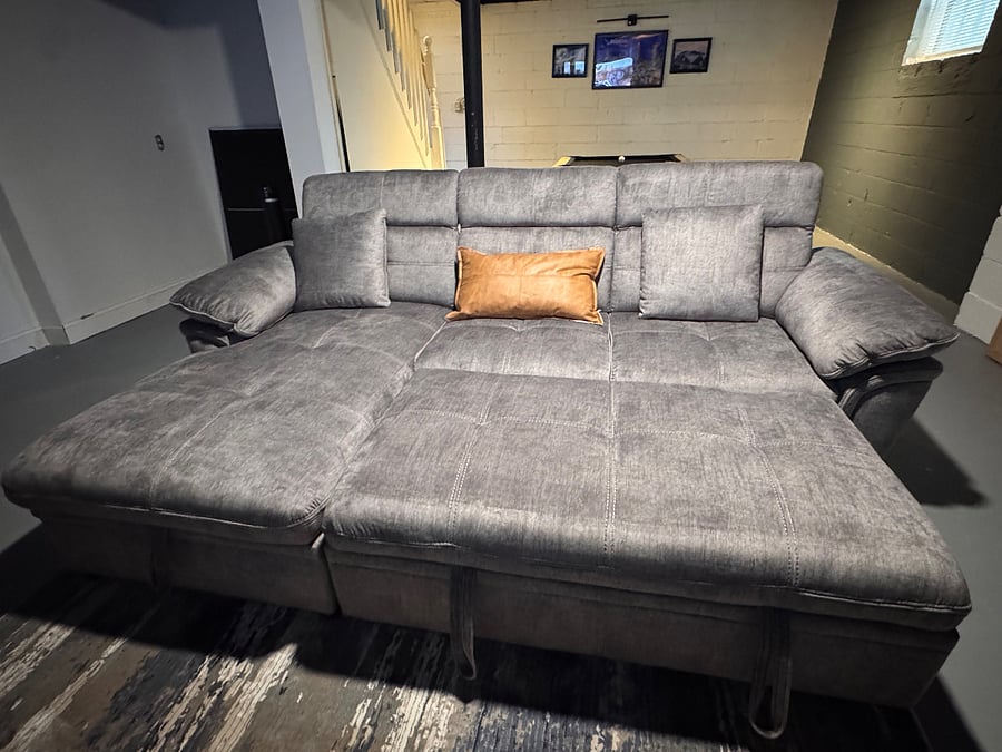 Cozy media room with a pop-out sleeper sofa, full bedding and linens perfect for movie nights or extra sleeping space.