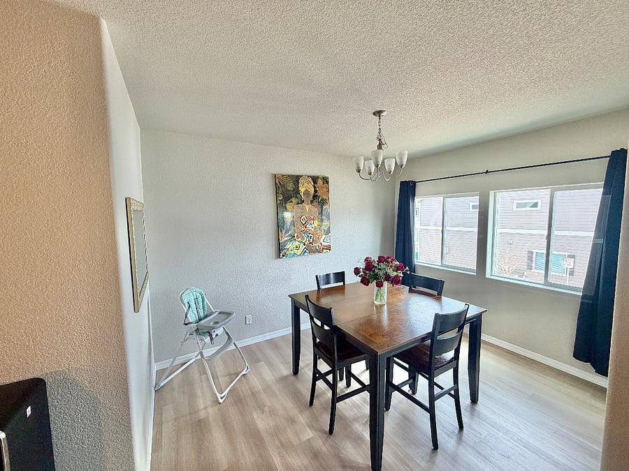 The dining area features a bar-height table and includes a high chair for children if needed, offering a functional and family-friendly setup.