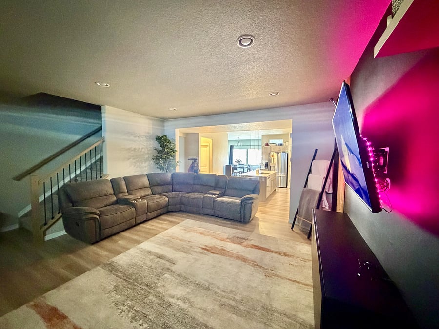 The living room is bright and inviting, with comfortable furniture, great natural and ambient lighting, and a smart TVperfect for relaxing, entertaining, or enjoying a quiet evening in.