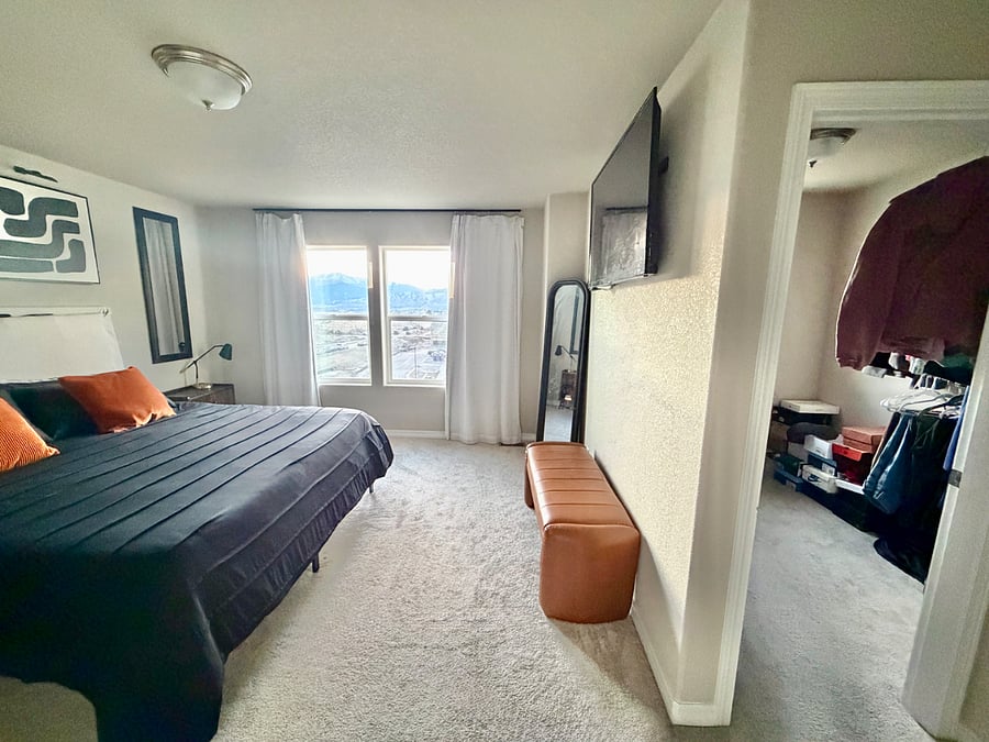 Master bedroom offers a king-size bed, dresser, TV, and a generous walk-in closet, along with a private en-suite bathroom. Enjoy stunning mountain views from this peaceful and well-appointed space.
