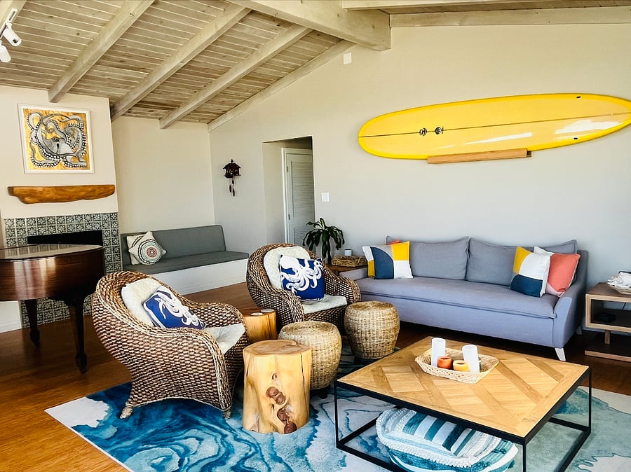 The living room is large with lots of seating. Decorated in California beach style. Beach views from the oversized windows.