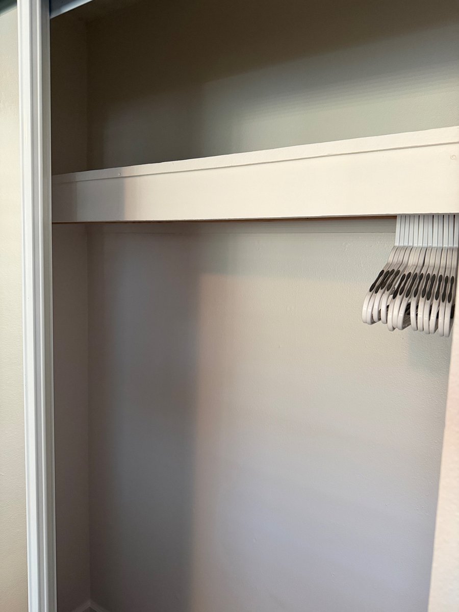 Interior view of sliding mirror closet with hangers 