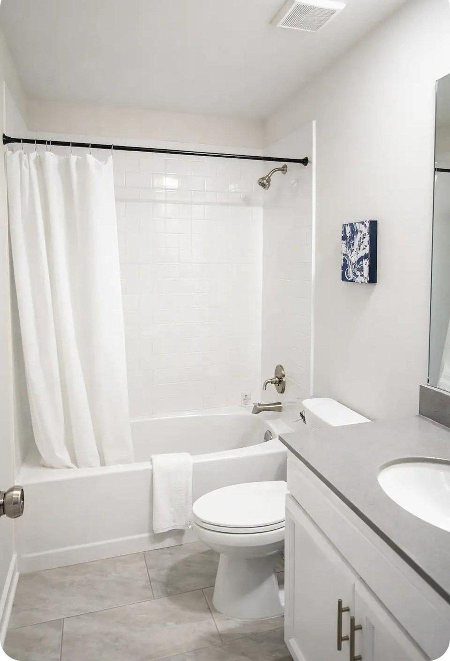 Clean full bath with tiled tub/shower combo, wide vanity with ample storage, and neutral finishes for easy upkeep.