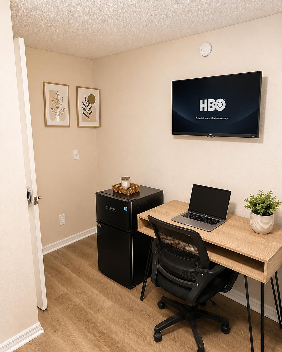 Dedicated work nook with a desk and office chair, plus a mini fridge and wall-mounted TV for added convenience.