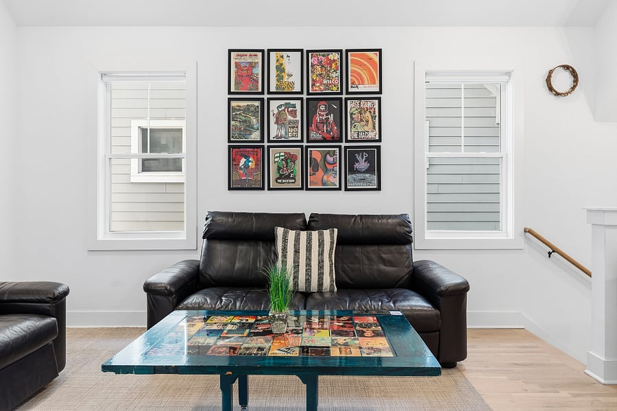 Second living room area on the second floor with comfortable seating, smart TV, piano and guitars.