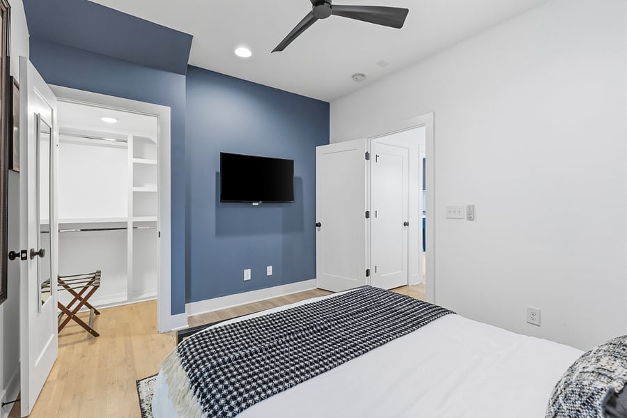 Queen sized bed with modern music decor in bedroom 2. Has smart TV with access to all the streaming apps and a closet.