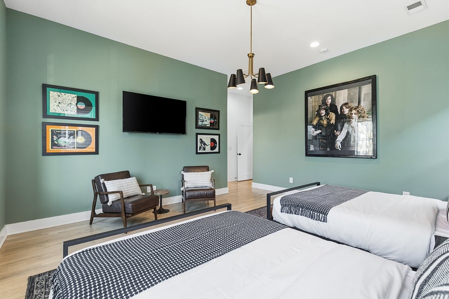 Bedroom 2 includes a queen and king bed, two accent chairs, and a smart TV with access to all the streaming apps. It also has a huge walk-in closet and large ensuite bathroom.
