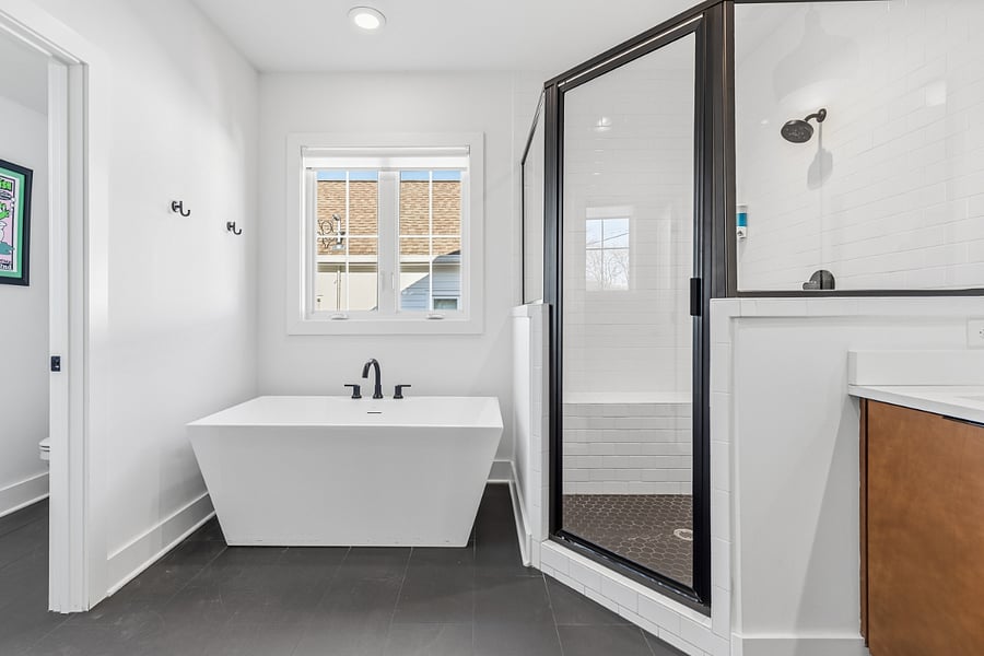 Beautiful, ensuite bath attached to bedroom 2 with standing shower, separate bathtub, and 2 sinks.