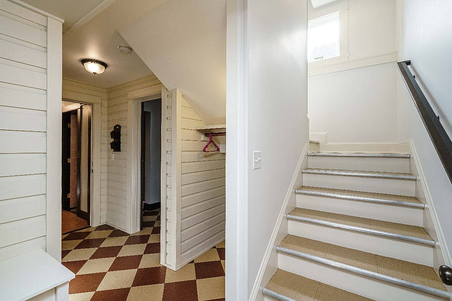 Lower level landing. Secure interior apartment entrance is to the left, stairs leading to first floor are on the right.