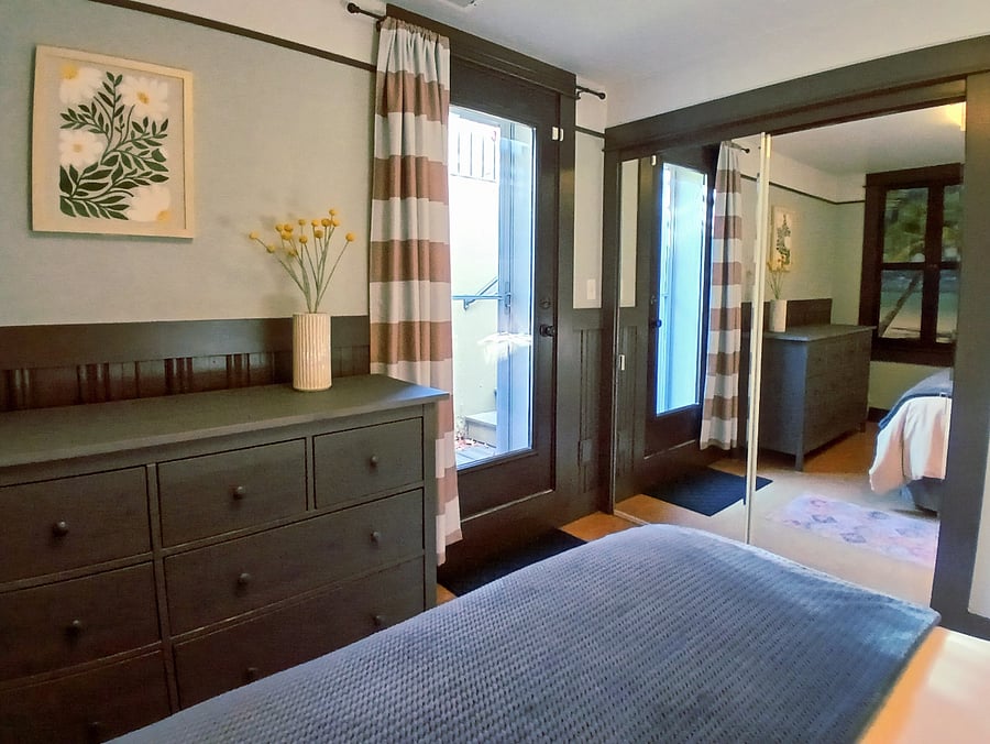Private apartment entrance into bedroom with queen bed, 8-drawer dresser and full-size closet