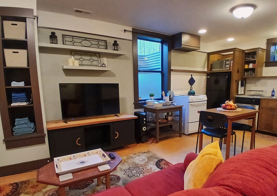 Apartment sitting area with 44-inch Roku TV, large window to garden and kitchen area